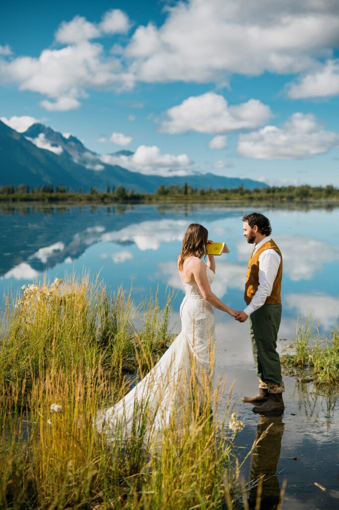 Bride and groom reading their vows together during their Alaska elopement